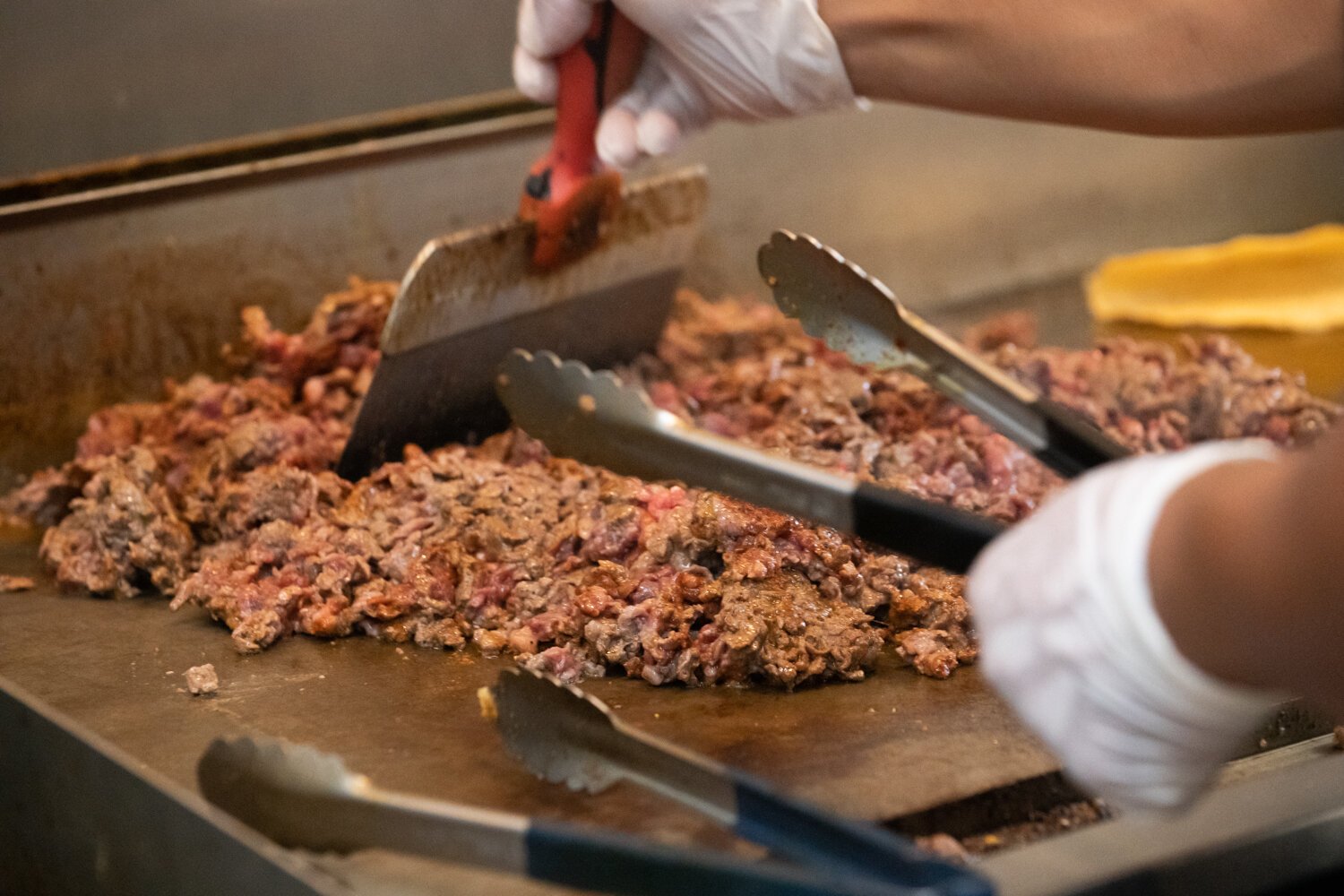 A worker prepares food for customers using meat from Wood Farms at Taco Zone, 6433 Bluffton Rd.